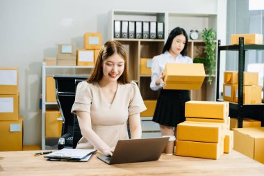 Küçük bir işe başlıyorum. KOBİ sahipleri çevrimiçi siparişleri kontrol ediyor, ürünler satıyor, ofiste kutularla dizüstü bilgisayarda çalışıyor