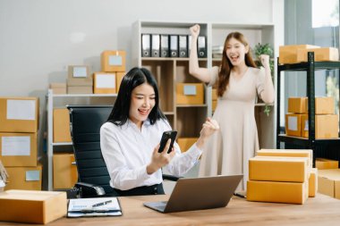 Küçük bir işe başlıyorum. KOBİ sahipleri online siparişleri kontrol edip ürün satıyorlar. Ofiste bilgisayarla ve kutularla akıllı telefonla çalışıyor.