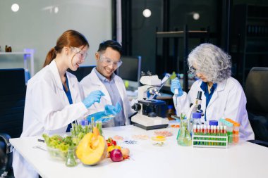 Laboratuvarda mikroskop ve pipetler kullanarak, örnekleri analiz ederek, yenilik, işbirliği ve gıda güvenliği araştırmalarını vurgulayarak yiyecek bilimcilerinin dinamik sahnesi