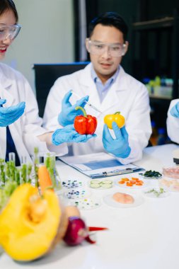 Laboratuvarda mikroskop ve pipetler kullanarak, örnekleri analiz ederek, yenilik, işbirliği ve gıda güvenliği araştırmalarını vurgulayarak yiyecek bilimcilerinin dinamik sahnesi