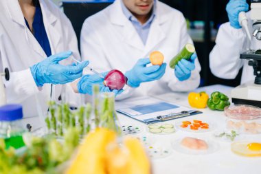 Laboratuvarda mikroskop ve pipetler kullanarak, örnekleri analiz ederek, yenilik, işbirliği ve gıda güvenliği araştırmalarını vurgulayarak yiyecek bilimcilerinin dinamik sahnesi