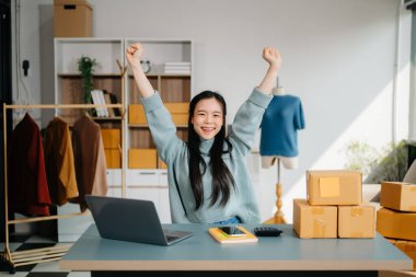 Genç iş kadını, bilgisayar ve el hareketleriyle modern bir ofisten online satış ve nakliyat yönetiyor. 