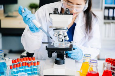 Modern tıbbi araştırma laboratuvarı. Kadın bilim adamı mikro pipetlerle çalışıyor biyokimyasal örnekleri analiz ediyor, tıp için ileri bilim kimya laboratuvarı. 