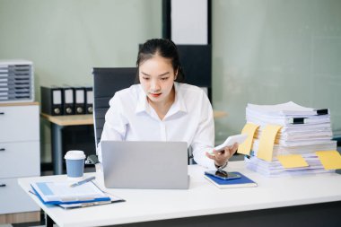 Genç ve güzel bir kadın çalışırken dizüstü bilgisayar kullanıyor. İşine odaklan.