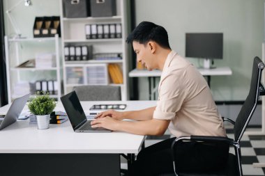 İşadamları, ofiste beyin fırtınası yaparken dizüstü bilgisayar kullanarak yeni bir projede işbirliği yapıyorlar.