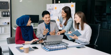 Ofiste beyin fırtınası yaparken dizüstü bilgisayar kullanan iş adamları yeni bir projede işbirliği yapıyorlar.