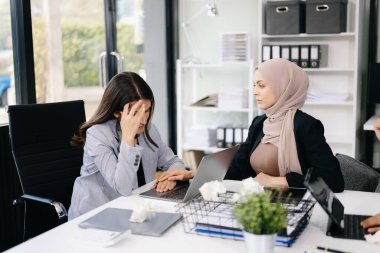 Ofiste beyin fırtınası yaparken dizüstü bilgisayar ve tablet kullanan iş adamları yeni bir projede işbirliği yapıyorlar