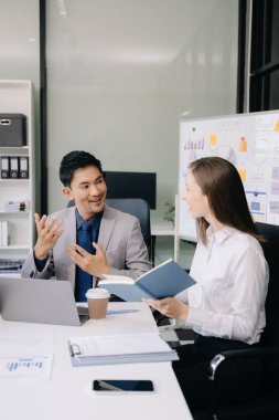 Ofiste beyin fırtınası yaparken dizüstü bilgisayar kullanan iş adamları yeni bir projede işbirliği yapıyorlar.