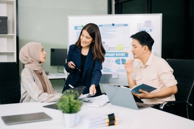 Ofiste beyin fırtınası yaparken dizüstü bilgisayar ve tablet kullanan iş adamları yeni bir projede işbirliği yapıyorlar