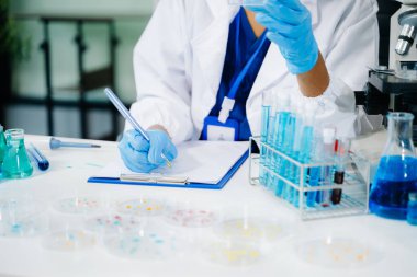 Modern tıbbi araştırma laboratuvarı. Genç kadın bilim adamının biyokimyasal örnekleri analiz eden mikro pipetlerle çalışan orta kesimi, tıp için ileri bilim kimya laboratuvarı. 