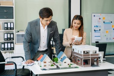Mimarlar, tasarımcılar veya geliştiricilerin modern ofis toplantısı, ofiste modeller kullanarak yenilikçi, sürdürülebilir konut projeleri yaratıyor.