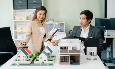 Modern office meeting of architects, designers or developers creating innovative, sustainable housing projects, using building models in the office, using digital tablet clipart