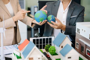 Mimarlar, tasarımcılar veya geliştiricilerin modern ofis toplantısı ofiste modeller ve küreler kullanarak yenilikçi, sürdürülebilir konut projeleri yaratıyor.