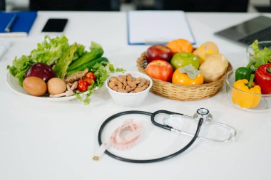 Taze sebzeler, meyveler, steteskop ve sağlıklı yiyecekler dengeli bir yaşam tarzı için tıbbi beslenme, sağlık ve diyet planlaması için birleştirildi..