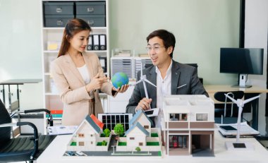 Mimarlar, tasarımcılar veya geliştiricilerin modern ofis toplantısı ofiste modeller ve küreler kullanarak yenilikçi, sürdürülebilir konut projeleri yaratıyor.