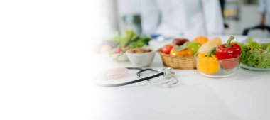 Taze sebzeler, meyveler, steteskop ve sağlıklı yiyecekler dengeli bir yaşam tarzı için tıbbi beslenme, sağlık ve diyet planlaması için birleştirildi. Metin için boşluk ile 