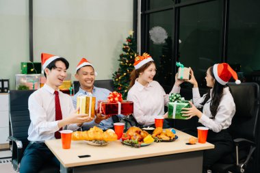 Meslektaşlar Noel 'i neşeli bir ofis partisinde kutluyor, hediyelerini paylaşıyor, ofislerinde gülüyorlar. 