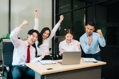 Ofiste yeni bir proje üzerinde çalışırken mutlu iş adamları. Ofiste dizüstü bilgisayar kullanan çeşitli iş adamları..