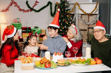 Asyalı Aile, Noel 'i lezzetli yiyeceklerle, sıcaklığı, neşeyi ve birlikte tatilin ruhunu yakalayarak rahat ve şenlikli bir ortamda kutluyor..