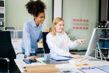 Yeni projeyi bilgisayarda tartışan bayan meslektaşlar 