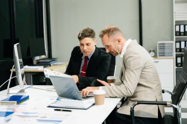 Ofiste yeni bir projede işbirliği yapan iş adamları. Bir grup farklı iş adamı ofiste birlikte çalışıyor..