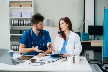 Doktorlar klinikteki hastanın sonuçlarını ya da teşhisini inceliyor. Hastanedeki mobil cihaz üzerinde tartışma ve araştırma yapan ekip çalışması, tıbbi ve sağlık çalışanları