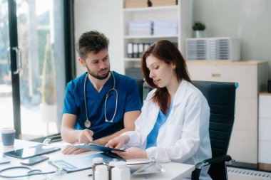 Doktorlar klinikteki hastanın sonuçlarını ya da teşhisini inceliyor. Hastanedeki mobil cihaz üzerinde tartışma ve araştırma yapan ekip çalışması, tıbbi ve sağlık çalışanları