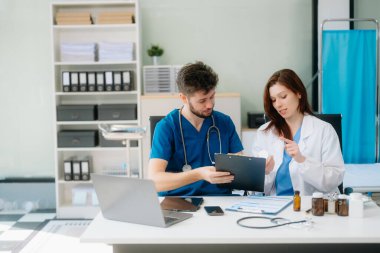 Doktorlar klinikteki hastanın sonuçlarını ya da teşhisini inceliyor. Hastanedeki mobil cihaz üzerinde tartışma ve araştırma yapan ekip çalışması, tıbbi ve sağlık çalışanları