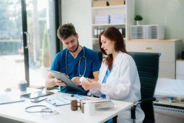 Doktorlar klinikteki hastanın sonuçlarını ya da teşhisini inceliyor. Hastanedeki mobil cihaz üzerinde tartışma ve araştırma yapan ekip çalışması, tıbbi ve sağlık çalışanları