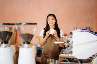 Kahve dükkanında kahve içen Asyalı barista ve şık bir kafede kahve kültürü sergiliyor.