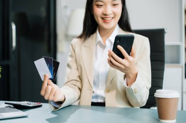 Akıllı telefon ve kredi kartı kullanan bir kadın cep telefonu ve online alışveriş için