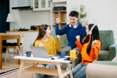 Gündelik kıyafetleri ve kulaklıkları olan genç yetişkinlerden oluşan canlı bir grup dizüstü bilgisayarlar, el hareketleriyle hareket eden eller, takım çalışmasının, yaratıcılığın ve rahat bir ortamda öğrenmenin tadını çıkarıyor. 