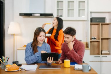 Rahat bir çalışma alanında dijital tablet üzerinde çalışan yaratıcı öğrenciler. Eğitim, yenilik ve uzak çalışma temaları için mükemmel