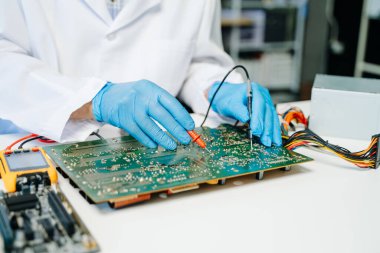 Teknisyen atölyedeki ana kartı tamir ediyor. 