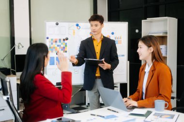 Asyalı işadamı, konferans odasındaki meslektaşlarına yeni başlatılan proje hakkında sunum yaptı