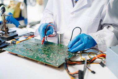 The technician repairing the motherboard in the workshop  clipart