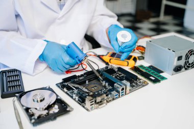 Teknisyen atölyedeki ana kartı tamir ediyor. 