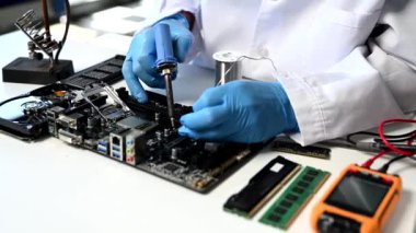 Teknisyen atölyedeki ana kartı tamir ediyor. 