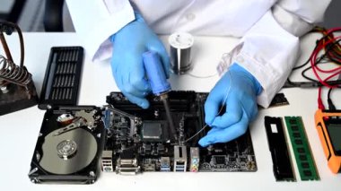 Teknisyen atölyedeki ana kartı tamir ediyor. 