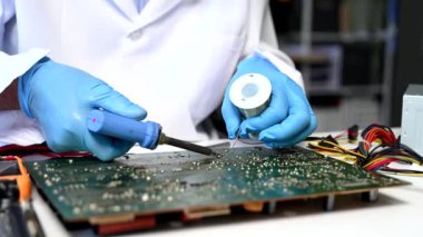 Teknisyen atölyedeki ana kartı tamir ediyor. 