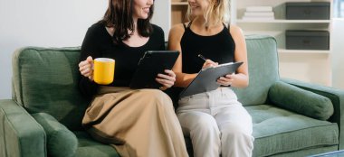 İki genç kadın yeşil kanepede rahat bir odada tablet kullanıyor. Canlı takım çalışmasını, yaratıcılığı ve genç yetişkinlerle öğrenmeyi keşfedin.. 