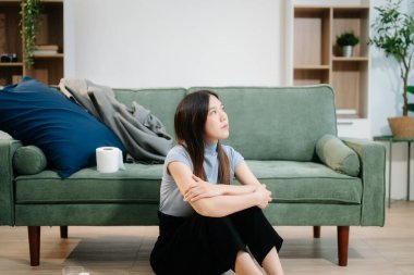 Asyalı kadın Buhran 'da oturur. Koyu saçlı, dalgın bakışlı. Pencere ve anksiyete dolu. Hastalık, sağlık ve iyileşme kavramı.