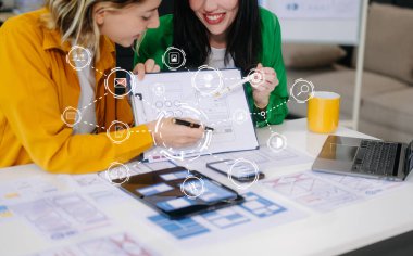 Modern ofiste müşteri özeti ve renk kodu ile mobil uygulama arayüzü kablo tasarımı hakkında fikir alışverişi yapan UX geliştiricisi ve ui tasarımcısı üzerindeki web simgeleri.