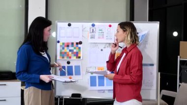 Ofiste birlikte çalışan iki iş kadını, yönetim kurulunu kullanarak yeni bir proje yürütüyorlar.