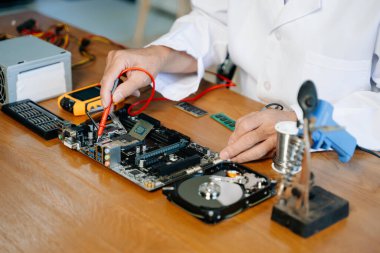 Teknisyen laboratuardaki ana kartı fotokopi aletiyle onarıyor. bilgisayar donanımı kavramı