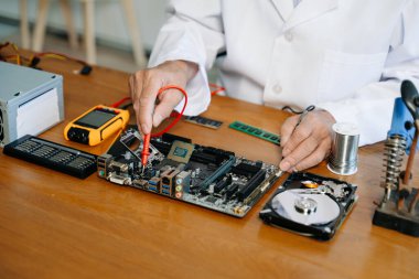 Teknisyen laboratuardaki ana kartı fotokopi aletiyle onarıyor. bilgisayar donanımı kavramı