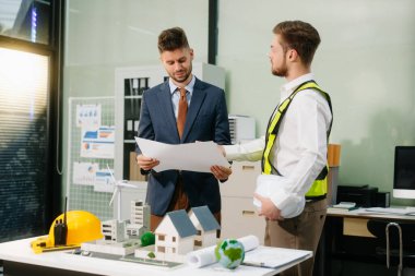 Müteahhit ve mimar büyük bir proje üzerinde çalışıp çalışmayacaklarını araştırıyor. İnşaat sürecinde bina içi. 