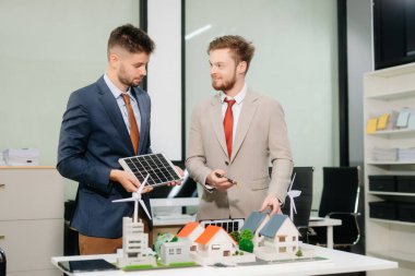 Uzmanlar, yeşil tasarım ve yeniliği vurgulayarak ev modelleri, rüzgar türbinleri ve güneş panelleri ile yenilenebilir enerji çözümleri üzerinde işbirliği yapmaktadırlar.