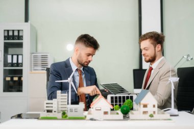 Uzmanlar, yeşil tasarım ve yeniliği vurgulayarak ev modelleri, rüzgar türbinleri ve güneş panelleri ile yenilenebilir enerji çözümleri üzerinde işbirliği yapmaktadırlar.