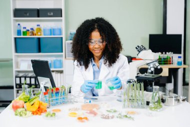 Gelişmiş teknoloji ve laboratuardaki hassas ekipmanları kullanarak sebzeleri güvenlik ve kalite için test edip analiz eden bir gıda bilimcisi.